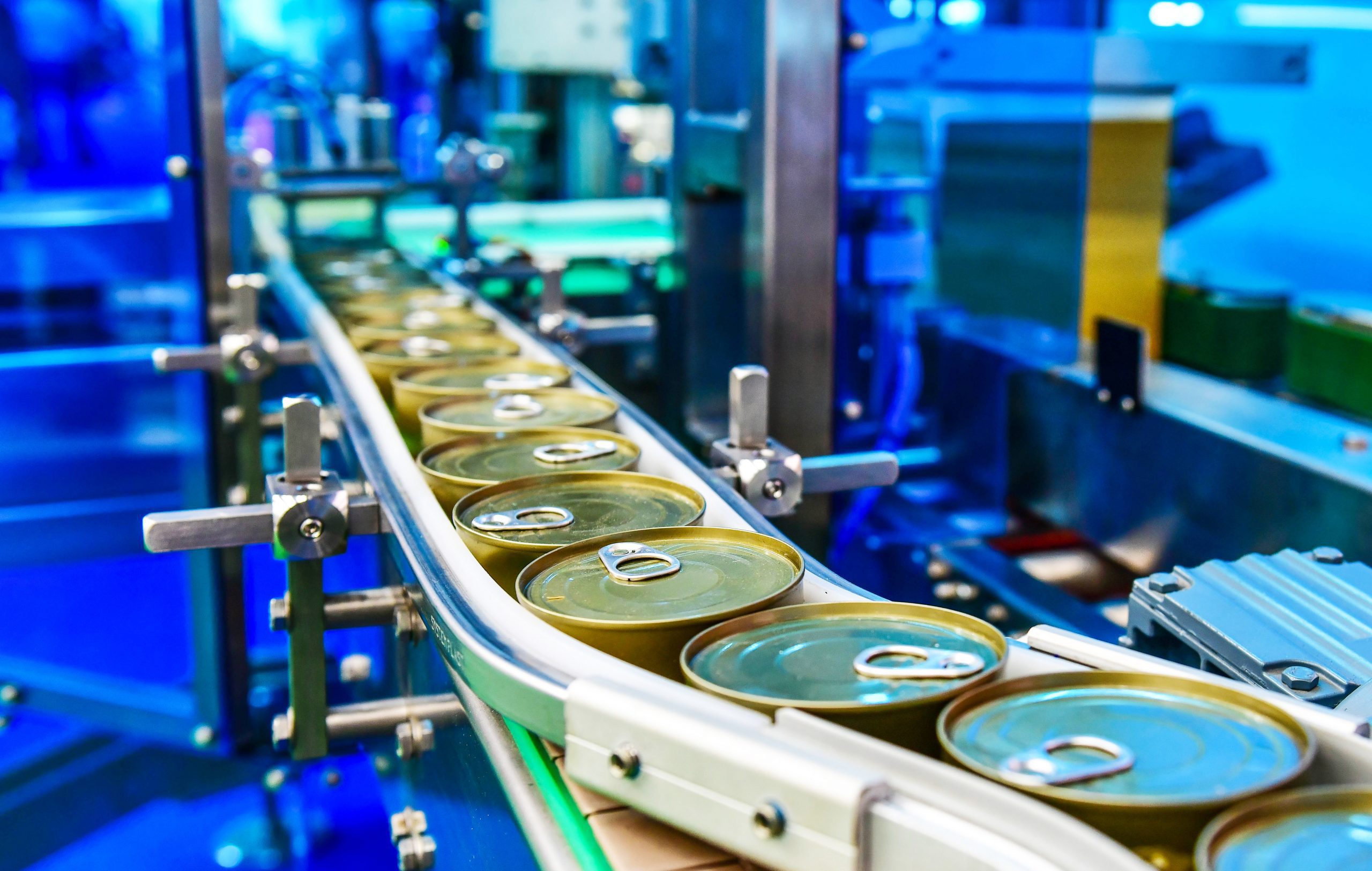 Canned food products on conveyor belt in distribution warehouse.parcels transportation system concept. cast nylon in food processing industry